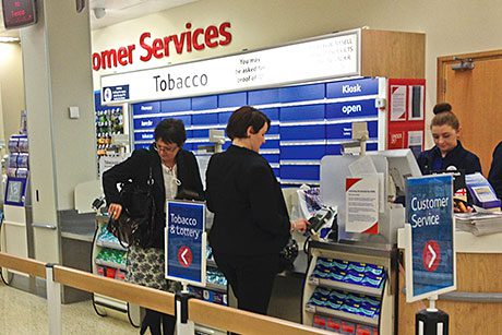 While the English version of the tobacco display ban (main picture above) allows a reasonable space to be displayed during transactions the Scottish system, now in supermarkets north of the border (inset picture), has led to kiosks being covered by potentially cumbersome systems of flaps.