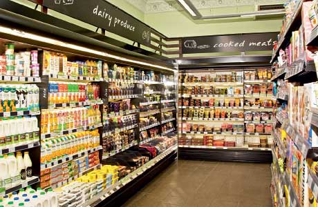 Inside Scotmid at Haymarket Terrace in Edinburgh. This page shows the open-deck chillers – arranged along the walls of the store to free up aisle space, the fruit and flowers close to the entrance and the market-like style of presentation on fruit and bread and bakery products.