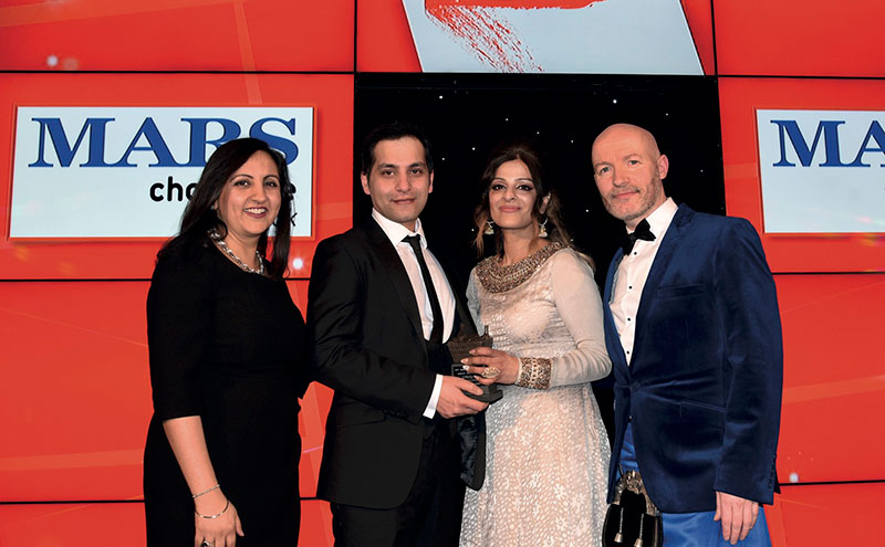 Bep Dhaliwal, trade communications manager, Mars Chocolate UK, left, and awards event host Craig Hill, right, present the Community Champion Award to Asif Akhtar and Abada Akhtar of Smeaton Stores, Kirkcaldy.