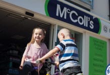 Two children play infront of a McColls store front
