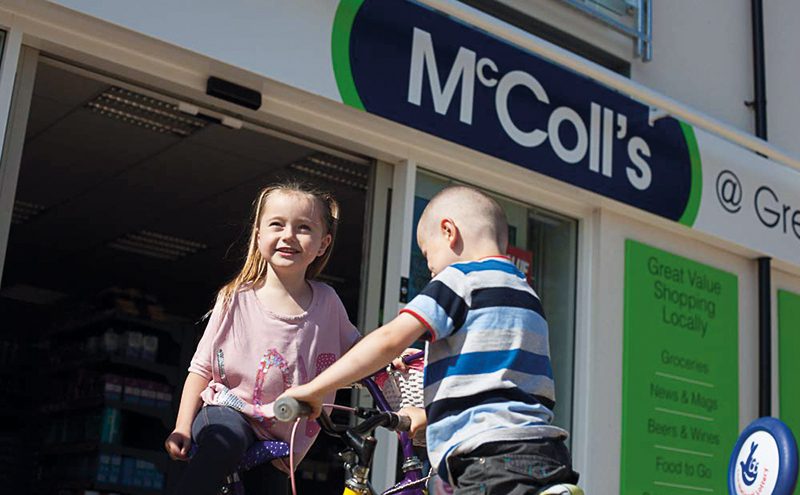 Two children play infront of a McColls store front
