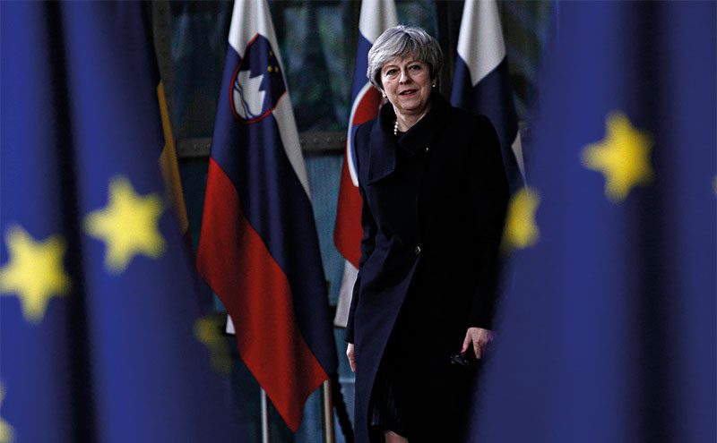 Theresa May and EU flags