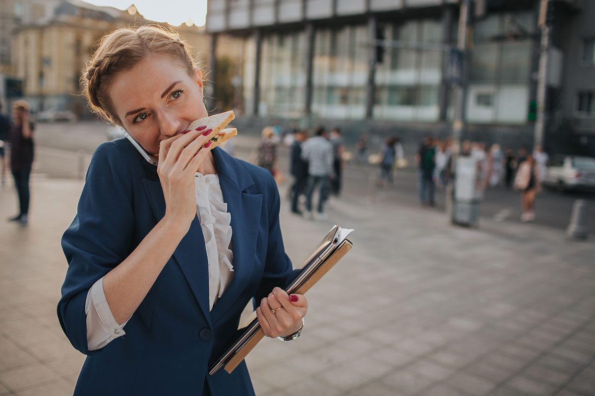 busy-woman-eating-sandwich