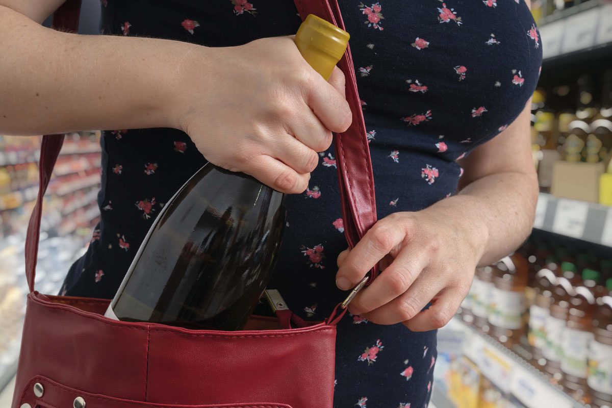 woman shoplifting wine