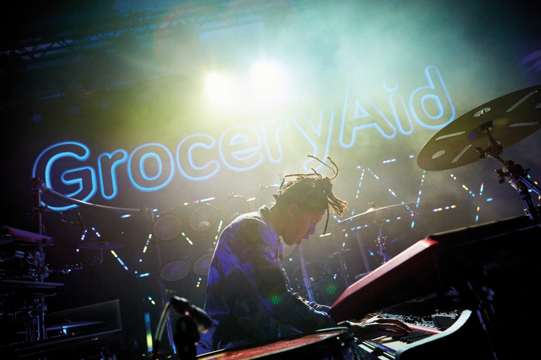 pianist infront of groceryaid sign