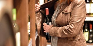 woman putting bottle in jacket