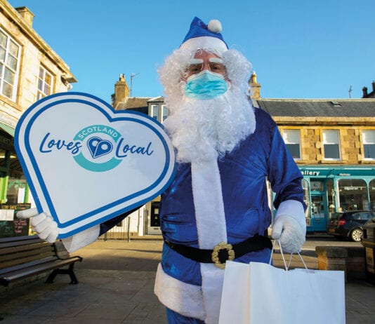 More support for local stores Blue santa with Scotland Loves Local sign