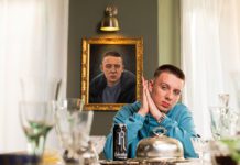 Man posing at dinner table with a can of Relentless