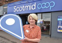 A woman standing outside Scotmid Coop Store Front