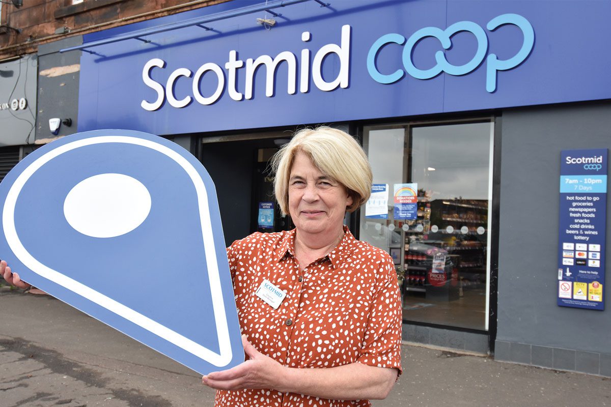A woman standing outside Scotmid Coop Store Front