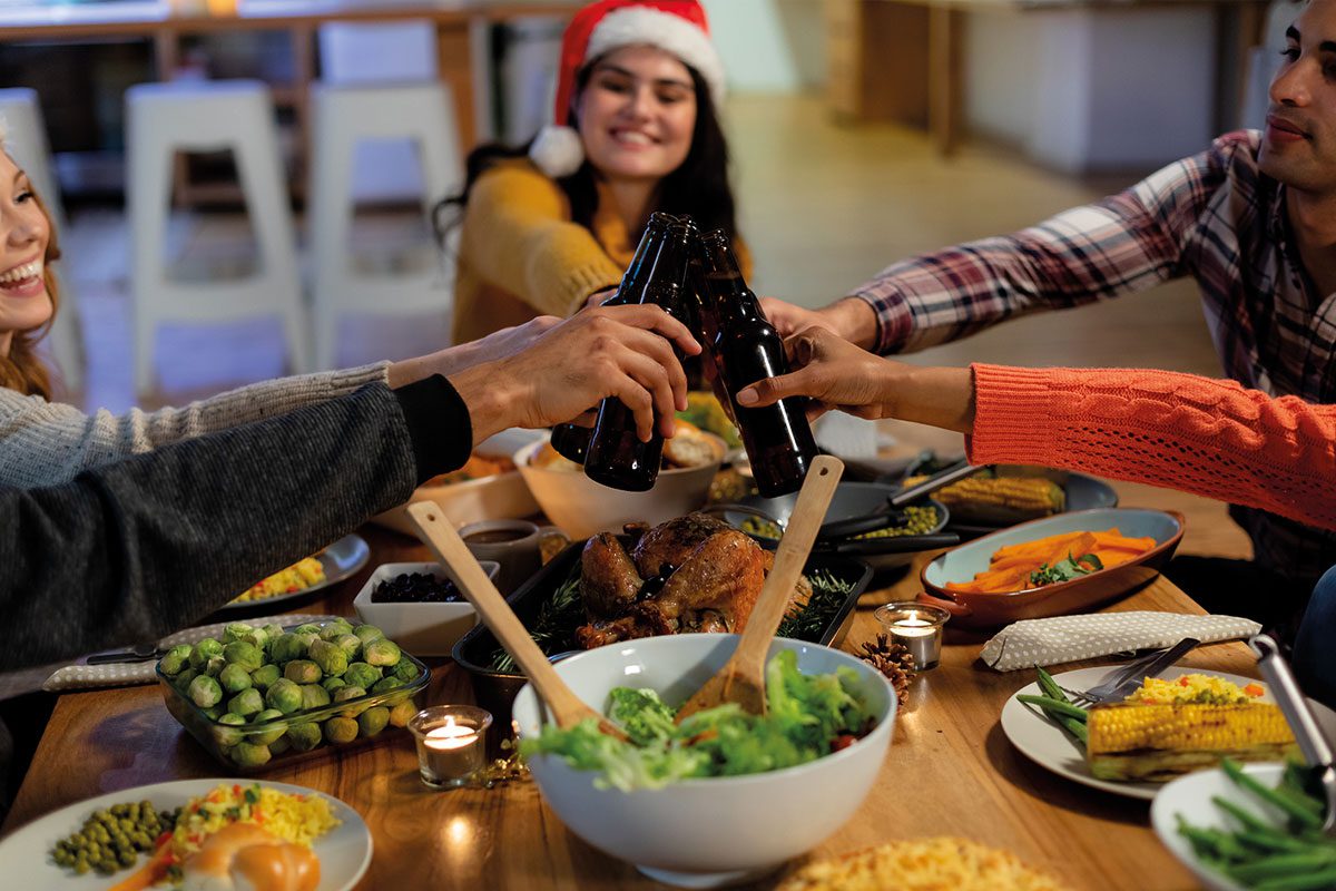 Friends having Christmas dinner with bottles