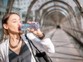 On the go is coming back Woman drinking water from bottle