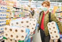 person in supermarket with lots of toilet/kitchen paper