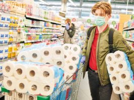Thriving despite cost pressures person in supermarket with lots of toilet/kitchen paper