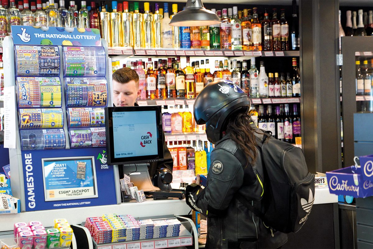 Woman wearing bike helmet at shop till