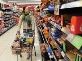 Turning to own label Customer in shopping aisle