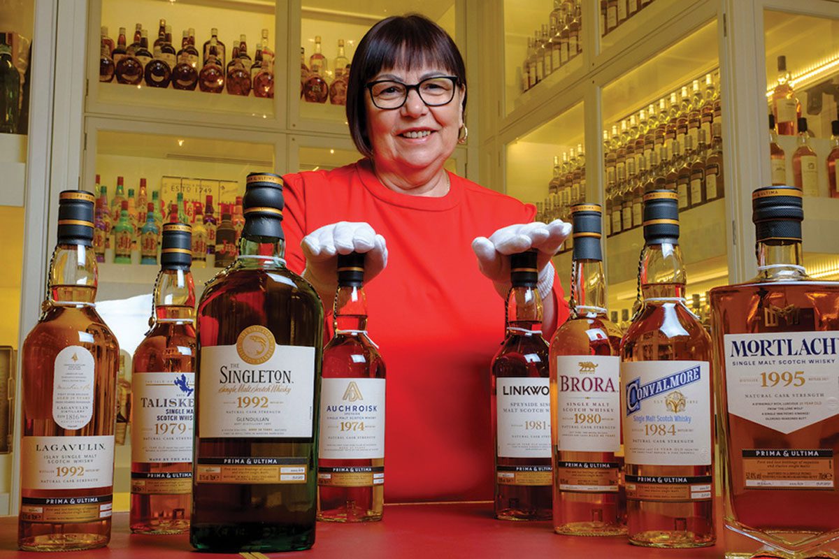 Maureen Robinson stands with various whiskey bottles from the diageo brand