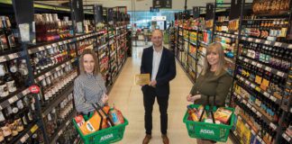 Three people stand in a supermarket aisle with baskets of scottish products