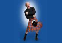 Image of comedian Craig Kelly wearing a black top and orange and blue kilt.