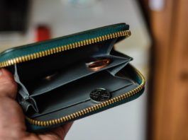 Consumers cut back open purse with pennies in it