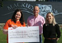 Three people with a giant cheque