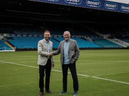 Scoring with Boost two men shaking hands on a football pitch