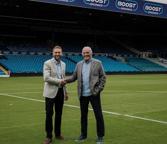Scoring with Boost two men shaking hands on a football pitch