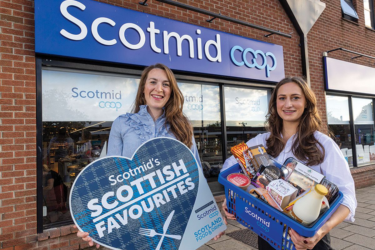 Two woman hold scottish products outside of Scotmid Coop