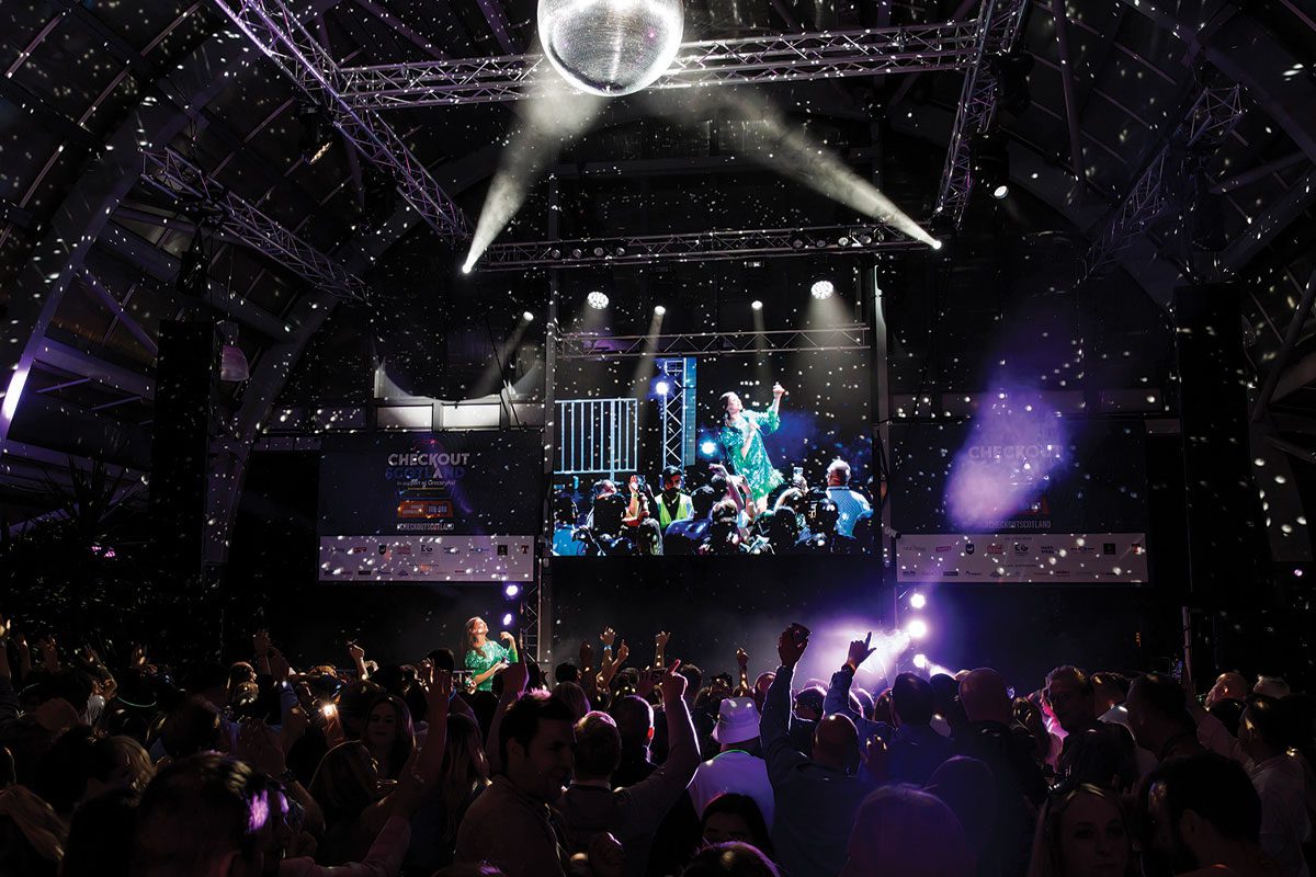 Photograph shows the inside of a nightclub with a disco ball on the roof