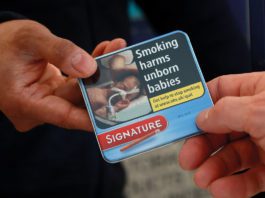 Miniature cigar sales gain momentum a hand passes a packet of miniature cigarettes to another