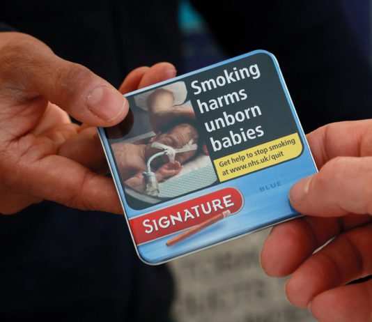 Miniature cigar sales gain momentum a hand passes a packet of miniature cigarettes to another