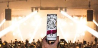 a hand holds a can of whiteclaw in a club