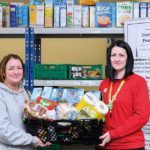 Donations hit milestone at Asda stores Two women hold a basket of food