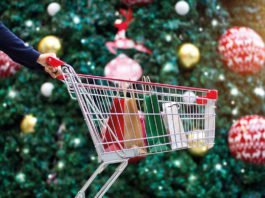 Savvy shoppers look for discounts this Christmas a shopping trolley infront of a christmas tree
