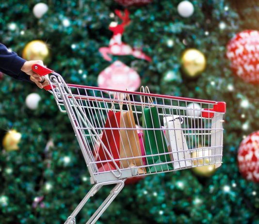 Savvy shoppers look for discounts this Christmas a shopping trolley infront of a christmas tree