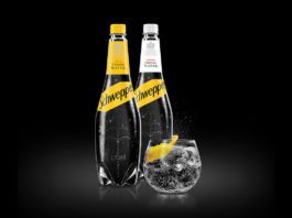 Adding soft drinks to the mix two bottles of schwepps tonic water and a glass on tonic with a lemon slice