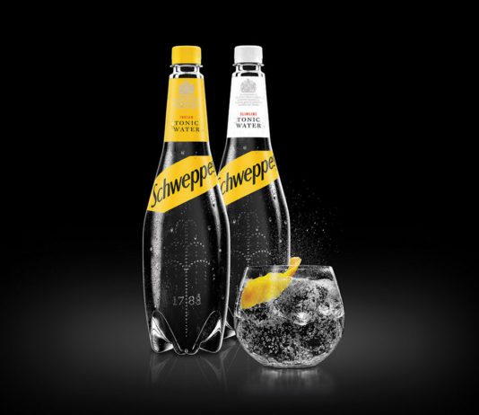 Adding soft drinks to the mix two bottles of schwepps tonic water and a glass on tonic with a lemon slice