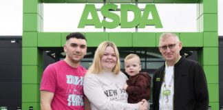 Parents hold their baby outside an ASDA store