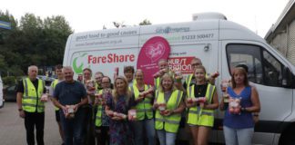 People stand infront of a Fareshare van holding pink lady apples