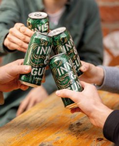 People cheers with cans of innis & gunn beer