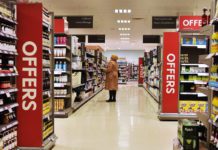 a woman stands in a supermarket aisle