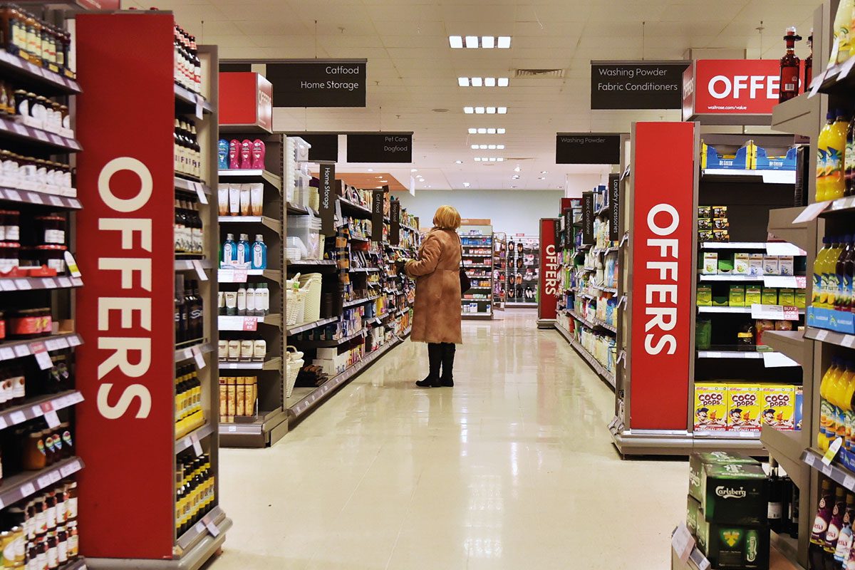 a woman stands in a supermarket aisle