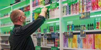 a person stocks the shelves of a vape store
