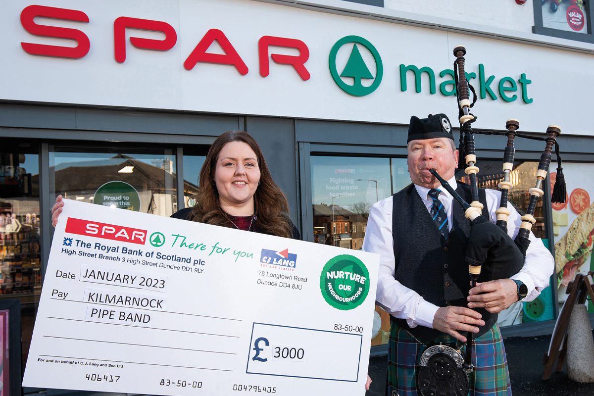 SPAR colleague with cheque and bag piper