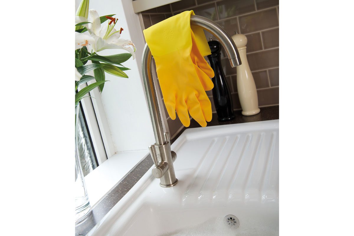 rubber gloves resting over a tap