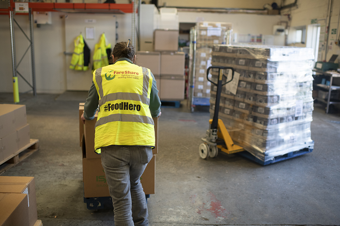 FareShare team member loading up surplus food in a Booker warehouse