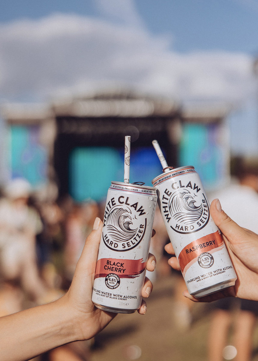 White Claw variants clinking together at a music festival