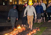 Spar Scotland colleague walking across fire with a Marie Curie hat on