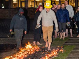 Flaming brave for charity Spar Scotland colleague walking across fire with a Marie Curie hat on