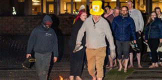 Spar Scotland colleague walking across fire with a Marie Curie hat on